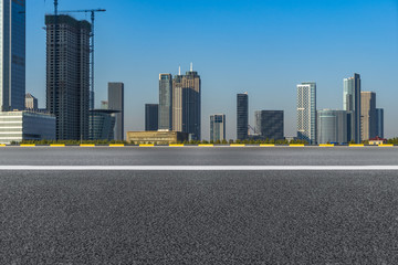 empty asphalt road front of modern buildings under blue sky