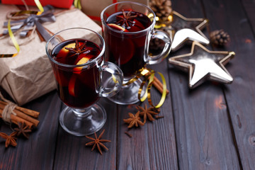 Christmas composition with gift boxes, mulled wine, baubles and decorations on dark wooden background. Christmas eve, New year celebration concept