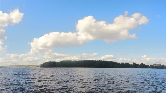 trees on shore of lake on a summer day timelapse