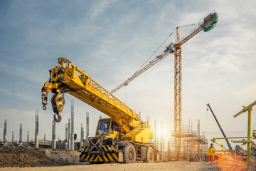 Fototapeta na wymiar Mobile Crane on a road and tower crane in construction site