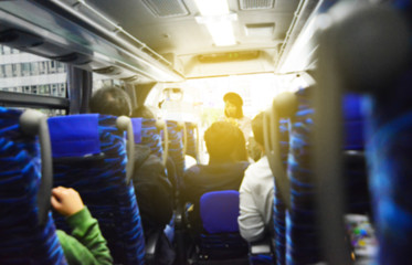 The beautiful women guide introduce plan for traveler in the bus - Blurred concept