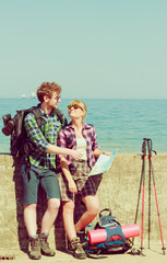 Fototapeta na wymiar couple backpacker with map by seaside