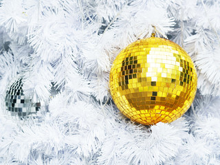 Close up golden glitter balls on white fir pine tree with copy space.