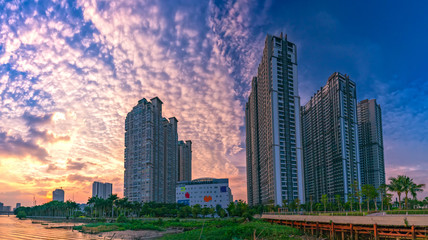 Fototapeta na wymiar Ho Chi Minh City, Vietnam - November 30th, 2017: Sunset in urban areas along river with skyscrapers read shine by sky dramatic create beauty of urban development in Ho Chi Minh City, Vietnam