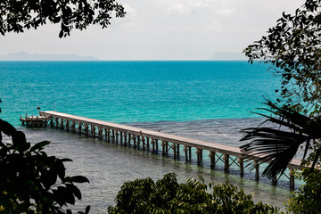 Fototapeta na wymiar concrete jetty surrounded by the tropical forest with blue ocean , Thailand