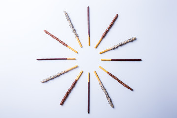Chocolate dipped biscuit sticks on white background