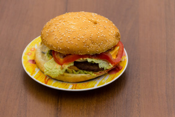 Delicious hamburger or sandwich on plate on wooden table