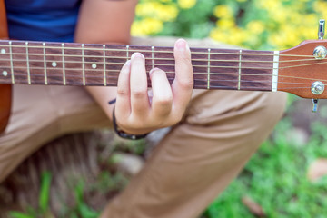 boy playing guitar in nature park outdoor