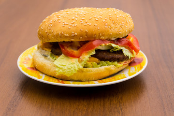 Delicious hamburger or sandwich on plate on wooden table