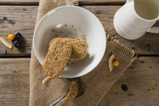 Granola bar and milk on wooden table