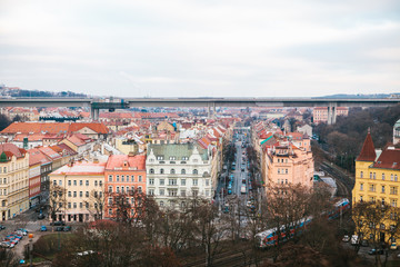 View from a high point. A beautiful view from above on the streets, roads and roofs of houses in Prague. Traditional ancient urban architecture. The road, the car is parked, ordinary life.