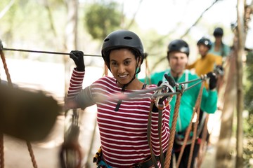 Friends enjoying zip line adventure in park