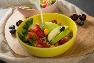 Milk being poured into bowl of breakfast cereal