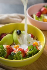 Milk being poured into bowl of breakfast cereal