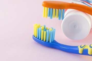 Baby toothbrushes and toothpaste on color background