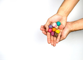 Macaroons hands holding on white background