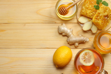 healthy background. honey, honeycomb, lemon, tea, ginger on light wooden table. Top view with copy space