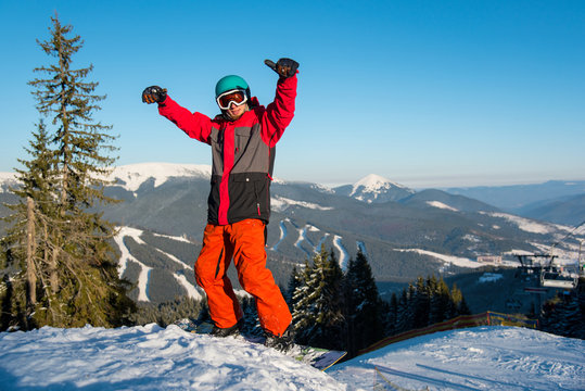 Excited snowboarder standing on the slope with his arms in the air in victorious gesture copyspace emotions recreation happiness positivity people recreational resort Bukovel