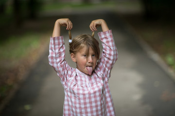 very funny cute girl showing tongue, with pigtails