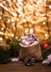 Beautiful silver Christmas decorations spilling out of a hessian sack