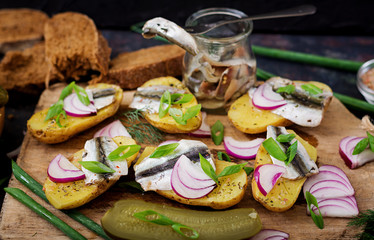Appetizer of herring anchovy and baked potato.