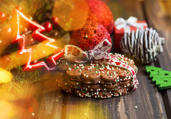 Christmas cookies  with festive decorations and colorful candies, chocolate Christmas cookies wrapped with a ribbon on a wood board with festive Christmas tree balls and ornaments