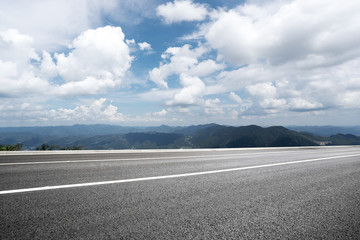 empty asphalt road with green hill in cloud sky