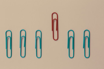 Colored paper red clip outstanding on pink background. minimal concept. Ideas about showing leadership in various ways. education, better business
