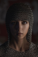 Portrait of beautiful medieval girl warrior in a chainmail hood.