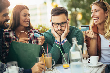 Group of four friends having fun a coffee together after shopping