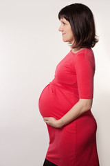 Pregnant Woman in red Cloth on Grey Background