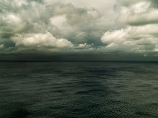 Calm ocean with advancing storm clouds