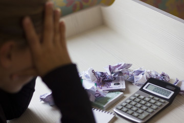 tired business woman sitting at Desk with crumpled banknotes