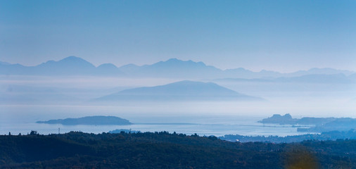 Sea and mountains in mist. Corfu island, Greece.