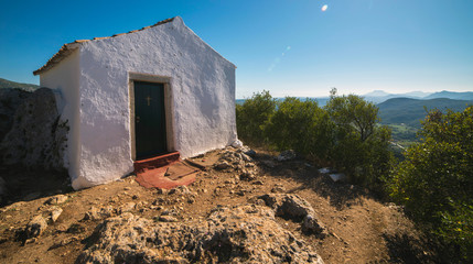 Old small white chapel, Ai Symeon, in mountains under clear blue sky. Doukades, Corfu, Greece.