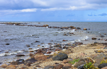 Fototapeta na wymiar Rocky seashore of Baltic sea, jetty like as S letter.