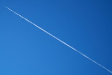 Diagonal airplane trace on a clear blue sky