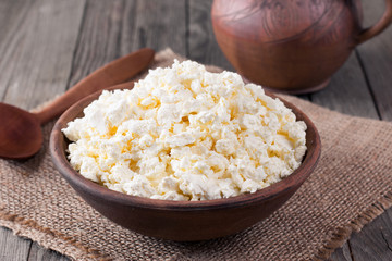 Homemade cottage cheese in a bowl on old wooden table