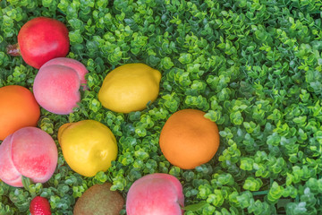 Colorful fruit on green grass, background. Mix fruits