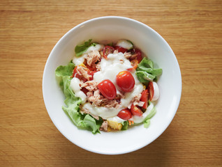 Bowl of Salad Tuna with fresh Leaf vegetable, tomato and cabbage, on wooden table background, Top view