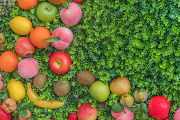Mix of colorful fruit on green grass, background