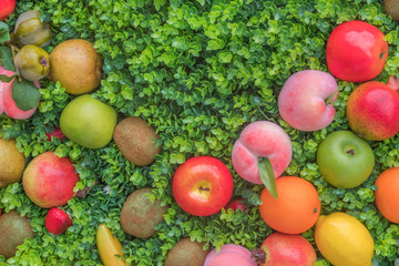 Variety colorful fruit on green grass, background