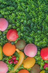 Mix of colorful fruit on green grass, background