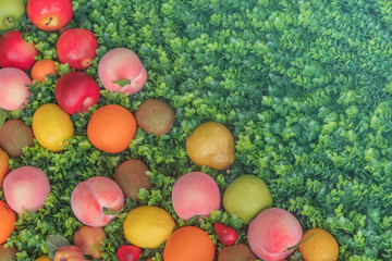 Colorful fruit on green grass, background