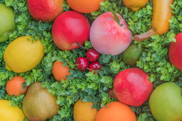 Mix of colorful fruit on green grass, background