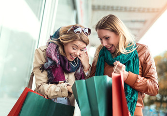 Happy friends shopping. Two beautiful young women enjoying shopping in the city.