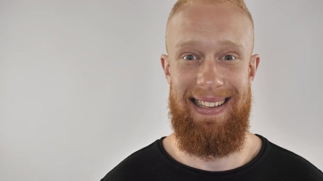 Close up smiling young man with beard and readhead. Portrait attractive hipster guy. Closeup face with red head posing with friendly smile.