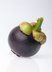 Mangosteen fruit and cross section showing the thick purple skin and white flesh of the queen of fruits.