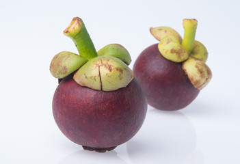 Mangosteen fruit and cross section showing the thick purple skin and white flesh of the queen of fruits.