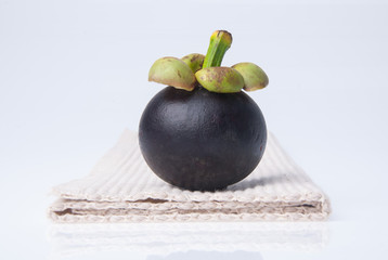 Mangosteen fruit and cross section showing the thick purple skin and white flesh of the queen of fruits.